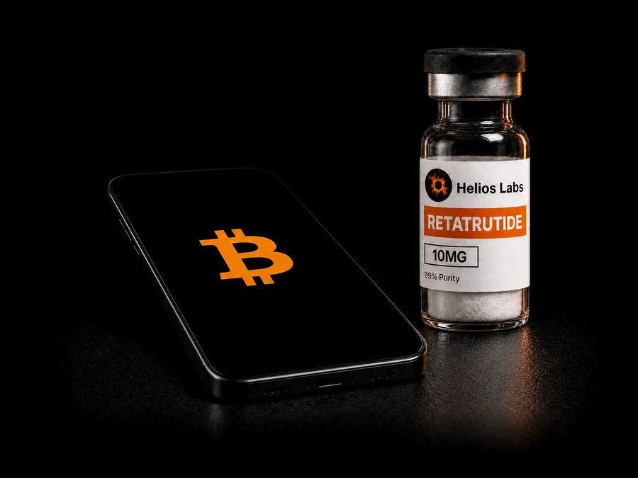A Helios Labs vial beside a phone showing the Bitcoin symbol
